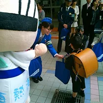 交通安全キャンペーンをする女性警察官とあつお