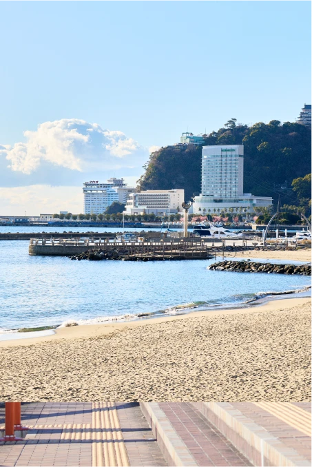 太陽が降り注ぐ、きらめくビーチと海辺の街並み。